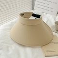 Beige wide brim sun hat with adjustable strap on white textured fabric for UV protection - Khaki