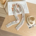 Chunky knit rainbow speckle scarf in light grey with a branded woven label on wood background - Confetti White