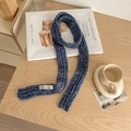 Blue knitted scarf with colorful speckles and woven brand label on wooden desk - Confetti Blue