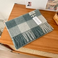 Close-up of a blue and white checkered 100% wool scarf with soft tassels on a table - 188x32cm / Blue Green White Plaid (6)