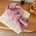 Sciarpa in maglia rosa con etichetta in tessuto su un tavolo di legno - Rosa pelle / 60-80cm