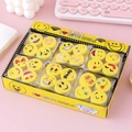 Macro-opname van ronde smiley-emoji gummen in een gele doos op een roze bureau - Set van 4