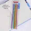 Five colorful 18cm flexible pencils with stripes and erasers on patterned notebook - Striped