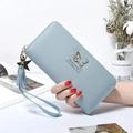 Cartera larga de mujer en color azul claro con detalle de mariposa y correa de mano - Azul