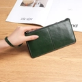 Portafoglio lungo da donna verde scuro con cerniera, trama in pelle lucida e cinturino - Verde