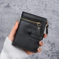 Black pebbled faux leather wallet with dual zipper and button detail held by a model - Black / 0.0