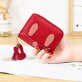 Red rabbit zipper wallet with pebble texture and tassel charm held by a hand - Red