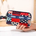 Porte-monnaie en toile à pois avec dragonne tendance tenu par une personne - Pois