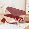 Women's long zipper wallet with color-block burgundy pink design and tassel charm - Red
