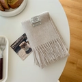 Elegant oatmeal beige 100% wool scarf with fringe tassels shown in a minimalist home setting - Beige