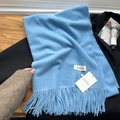 Light blue cashmere-feel winter scarf with dense tassel fringe on a black suit jacket - Aquamarine