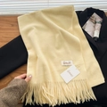 Pale yellow baby fleece scarf with tassels and brand tag on black suit background - Pear Yellow