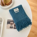 Dark teal 100% wool scarf with soft fringes and authentic label in a cozy home setting - Autumn Smoke Blue