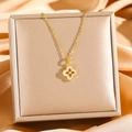 Elegant gold titanium necklace with white shell clover pendant on luxury silk background - Gold White Shell