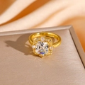 Primo piano di un anello dorato con un grande zircone quadrato e un alone di diamanti - Anello con zirconia quadrata dorata