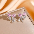 Dettaglio macro di orecchini a fiocco in argento con zircone cuore rosa e frange - Orecchini a Bottone a Fiocco / Argento