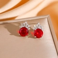 Macro shot of red gemstone earrings with crown-shaped diamond halo on jewelry stand - Silver Red Zirconia Stud Earrings