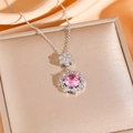 Halskette mit rosa Zirkon-Blumenanhänger und Ohrringen auf glänzender Seide präsentiert - Silberne Halskette