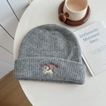 Grey knitted beanie with white puppy embroidery and Lucky PiEgg text in a cozy setting - Hat—Medium Gray