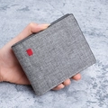 Schlanke graue Herren-Brieftasche aus Stoff mit Textur und kleinem rotem Etikett - Grau
