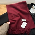 Deep red soft knit scarf with fringe tassels draped over a black suit jacket - Ancorra Red