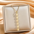 Goldene Quastenkette mit sechs weißen Emaille-Blumen auf einer Seiden-Schmuckschatulle - Goldene weiße Fünf-Blumen