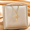Collana con ciondolo a stella croce dorata e zirconi su sfondo di seta lussuoso - Croce con Strass a Stella Oro