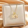 Collana dorata con ciondoli a croce e lucchetto con diamanti incastonati su seta di lusso - Oro