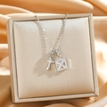Collana in acciaio al titanio con croce di cristallo e lucchetto su raso dorato di lusso - Argento