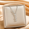 Collier à pampilles étoiles en argent avec zircons sur coffret en satin champagne - Frange d'étoile argentée