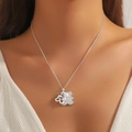 Dettaglio della collana d'argento con fiocco e ciondolo a fiore di perle su tessuto - Argento