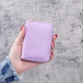Purple litchi pattern mini wallet with zip closure held in hand for size display - Purple