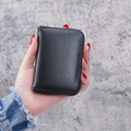 Black lychee pattern accordion card wallet with golden zipper shown in hand - Black
