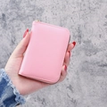 Pink lychee grain leather card holder wallet with gold zipper, shown held in hand - Pink