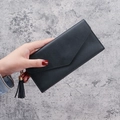 Women's black pebbled leather long clutch wallet with envelope flap and tassel charm - Black