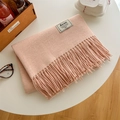 Écharpe en tricot rose pâle avec franges et étiquette sur une table blanche décorée - Rose Lotus