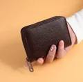 Détail d'un porte-cartes en cuir grainé marron foncé avec fermeture éclair métallique - Marron