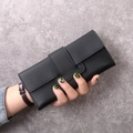 Detail of black long wallet with cross-pattern leather and wide strap buckle closure - Black