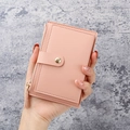 Slim pink faux leather card holder with gold zipper and button closure held in hand - Light Pink