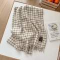 Beige and dark brown plaid scarf with tassels and vintage label on a white surface - Slanted Line Small Grid Beige