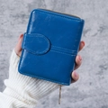 Short vintage oil wax leather wallet in dark blue held by a model in a white sweater - Dark Blue