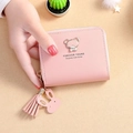 Pink mini PU leather wallet with bear charm and tassel, held in hand for size display - Pink