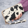 Women's long zip-around wallet featuring a stylish black and white cow print and wristlet - Khaki
