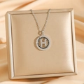 Lujoso collar dorado con colgante de letra H y cristales sobre joyero elegante - Plata Redondo H (8292)