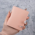 Slim pink leather card holder with fine stitching shown in a minimalist hand-held view - Light Pink