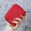 Red lychee pattern PU leather card holder wallet with gold zipper held by hand - Red