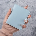 Schlankes hellblaues Leder-Kartenetui und minimalistische Brieftasche in der Hand gehalten - Blau