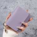 Purple lychee leather card holder with gold keychain and ring held in hand - Purple