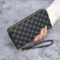 Lange Reißverschluss-Geldbörse aus schwarzem Leder mit Kleeblatt-Monogramm und Handgelenkschlaufe - Schwarz