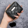Women's black quilted short wallet with gold hardware and a soft faux fur pompom charm - Black